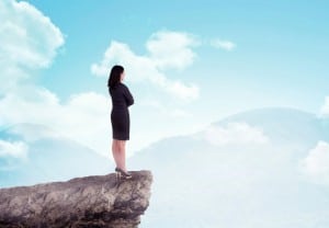 Asian business woman standing on top of the mountain. Business success concept