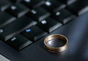 A wedding ring sits on a laptop keyboard